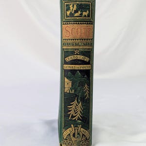 May include: A green hardcover book spine with gold embossed details. The text reads SCOTT, ILLUSTRATED, LANDSCAPE, SERIES OF POETS, and GALL & INGLIS. The design features a mountain landscape with trees, a small building, and a lyre emblem at the base.