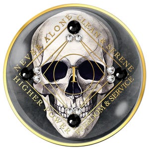 Puede incluir: Un emblema redondo con borde dorado, con un diseño detallado de calavera. La calavera está adornada con gemas negras y transparentes, y líneas geométricas doradas. Las palabras "NEVER ALONE", "CLEAN & SERENE", "HIGHER POWER" y "FREEDOM & SERVICE" están inscritas.