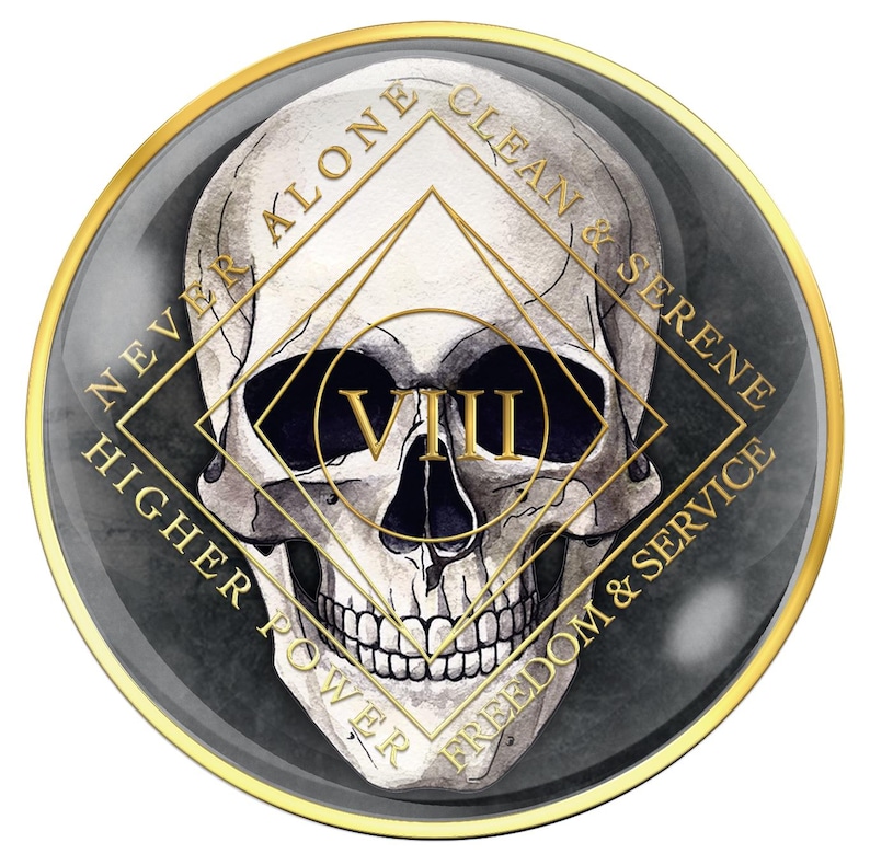 May include: A round, dark gray emblem with a gold border featuring a skull illustration. Gold text reads "NEVER ALONE", "CLEAN & SERENE", "FREEDOM & SERVICE", and "HIGHER POWER". The Roman numeral "VIII" is in gold.