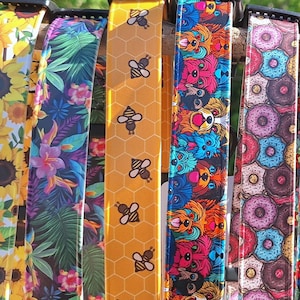 Waterproof dog collars with various patterns including bees, donuts, owls, and flowers. The collars are made of Biothane.