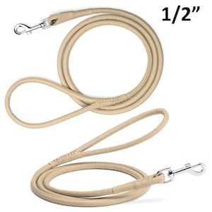 May include: A beige leather dog leash with a silver-colored metal clasp. The leash is 1/2 inch thick and features a loop handle. The leash is coiled and has a stitched section near the handle.
