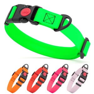 May include: A neon green dog collar with a black buckle and a red release button. The collar has a black loop for leash attachment and a stitched square detail. Additional collars in orange, red, pink, and light purple are shown below.