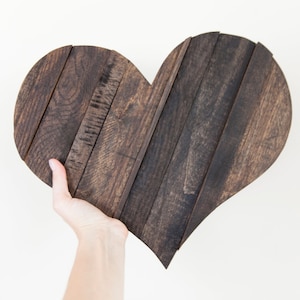 May include: A dark brown wooden heart-shaped wall decor made from reclaimed wood planks.