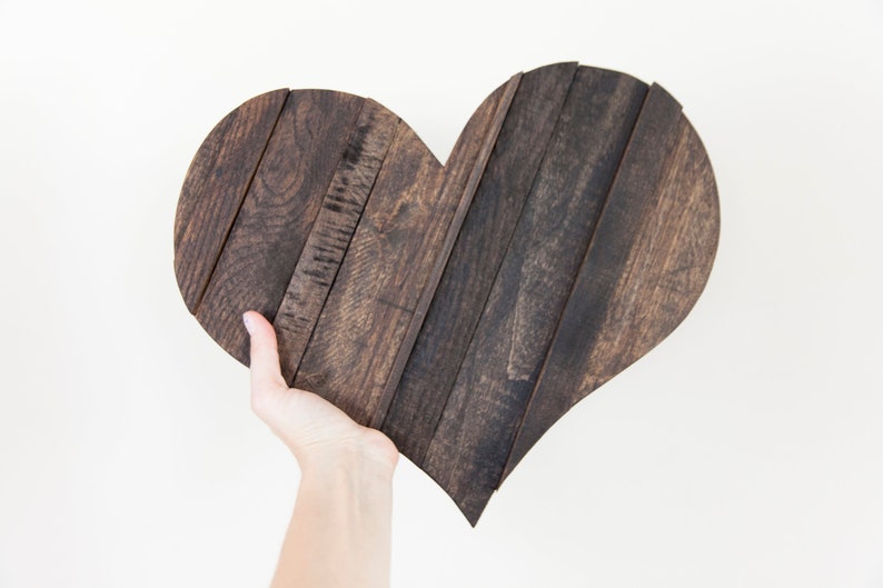 May include: A dark brown wooden heart-shaped wall decor made from reclaimed wood planks.