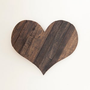 May include: A dark brown wooden heart-shaped wall decor made from reclaimed wood planks.