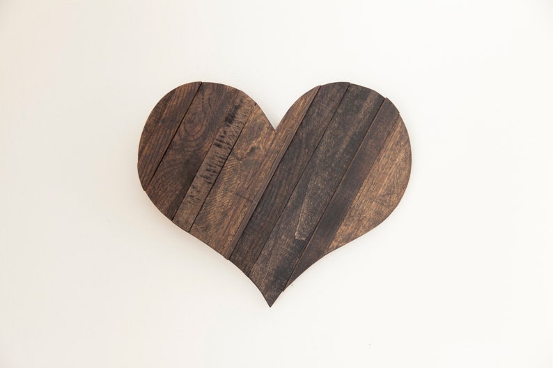 May include: A dark brown wooden heart-shaped wall decor made from reclaimed wood planks.