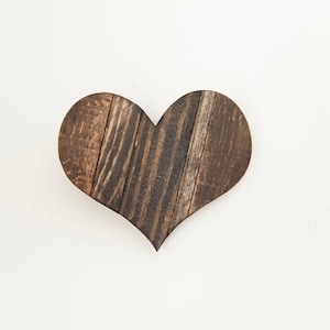May include: A dark brown wooden heart-shaped wall decor made from reclaimed wood planks.
