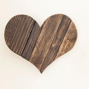 May include: A dark brown wooden heart-shaped wall decor made from reclaimed wood planks.