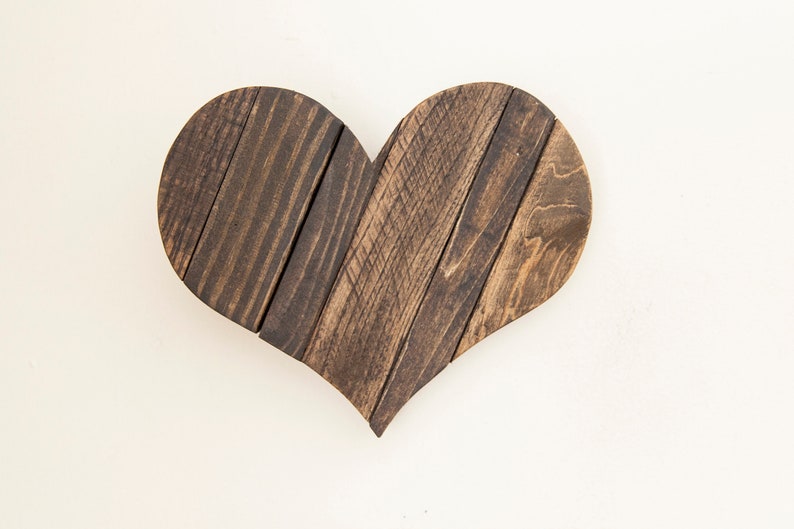 May include: A dark brown wooden heart-shaped wall decor made from reclaimed wood planks.