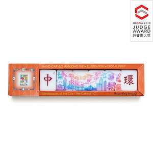 May include: A boxed set of hand-carved mahjong tiles. The tiles feature colorful illustrations of cityscapes, with the text "Landscapes of the City - The Central 'C'" and Chinese characters. The box is orange with the text "Unique hong kong gift".