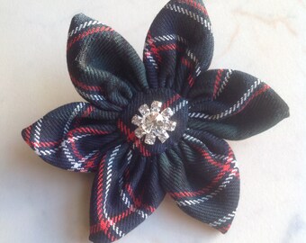 May include: A black, red, and white plaid fabric flower with a silver rhinestone in the center.