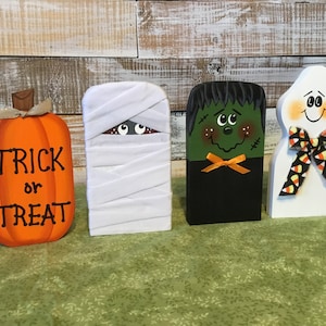 Trick or treat. Halloween decor. Ghost, mummy, Frankenstein, and pumpkin. Fun Halloween decor. Hand made and hand painted out of wood.