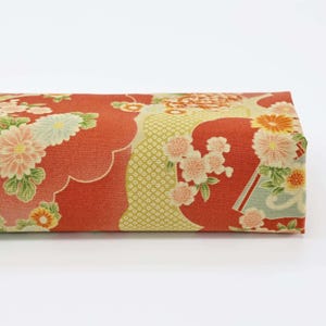 Peut inclure: Tissu rouge avec un motif floral composé de fleurs jaunes, blanches et vertes. Le tissu présente un motif japonais traditionnel avec des nuages et des motifs géométriques.