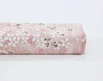 May include: A pink fabric with a white floral pattern. The fabric has a subtle texture and is perfect for crafting projects.