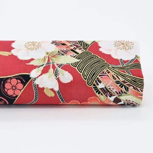 May include: Red fabric with a Japanese-inspired floral and geometric pattern. The fabric features white flowers, gold accents, and black and red geometric shapes.
