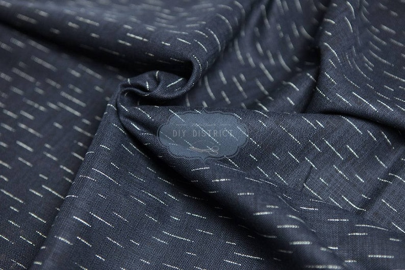 May include: A close-up of a dark blue fabric with a subtle white stripe pattern. The fabric has a soft, textured feel and is perfect for crafting projects.