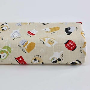 Peut inclure: Tissu roulé avec un motif répété de chats de dessins animés dans diverses poses et tenues, avec du texte et des illustrations japonais. Les chats sont noirs, blancs, jaunes et verts, sur un fond beige.
