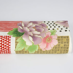 Peut inclure: Un tissu blanc avec un motif floral composé de fleurs roses, violettes et vertes. Le tissu présente également un motif géométrique avec des accents rouges, blancs et dorés.