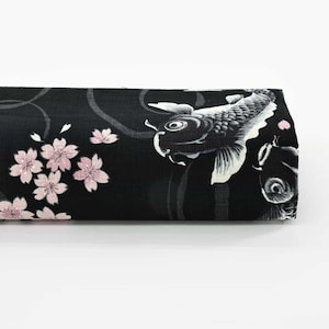 Peut inclure: Tissu noir avec un motif de carpes koï et de fleurs de cerisier. Le tissu présente un motif répété de carpes koï blanches, de fleurs de cerisier roses et de lignes grises en spirale. Le tissu est enroulé et prêt à l'emploi.
