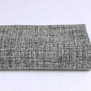 Peut inclure: Un tissu plié de près avec un motif moucheté noir et blanc.