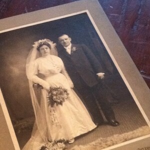Fotografía de retrato antiguo de una joven pareja de novios en un gabinete vintage. Foto del novio y la novia.