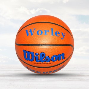 May include: An orange basketball with black lines and the word "Wilson" in blue lettering. The basketball has the words "Worley" in blue lettering on the top.