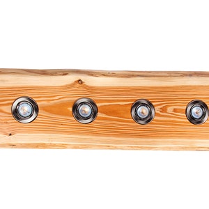 May include: A wooden light fixture with four recessed lights. The fixture is made from a natural wood slab with a rustic finish.