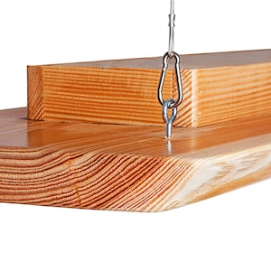 May include: A wooden shelf with a natural finish, hanging from two silver chains with metal hooks. The shelf is made of two pieces of wood, one on top of the other.