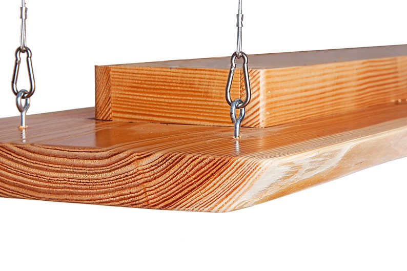 May include: A wooden shelf with a natural finish, hanging from two silver chains with metal hooks. The shelf is made of two pieces of wood, one on top of the other.