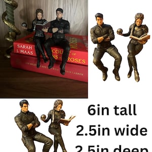 May include: Two detailed figurines of a man and a woman in dark tactical clothing. The man sits with arms crossed, while the woman holds a small sphere and an open book. The figures measure 6 inches tall, 2.5 inches wide, and 2.5 inches deep.