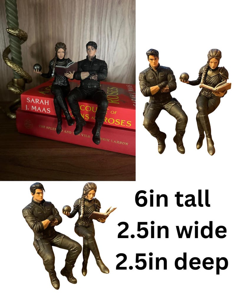 May include: Two detailed figurines of a man and a woman in dark tactical clothing. The man sits with arms crossed, while the woman holds a small sphere and an open book. The figures measure 6 inches tall, 2.5 inches wide, and 2.5 inches deep.