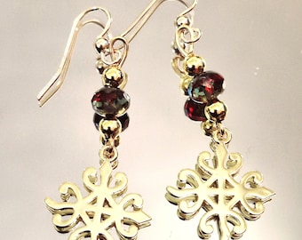 May include: Gold dangle earrings with a geometric design and red and green crystal beads.