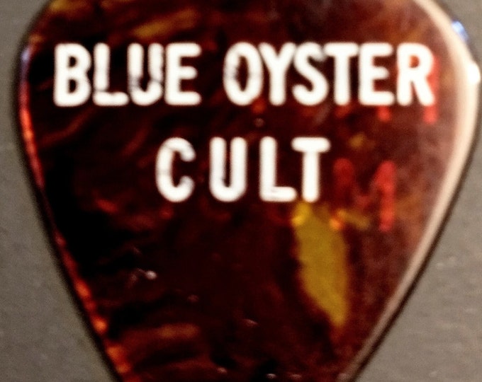 Featured listing image: Blue Oyster Cult, Guitar Pick, RARE PASTORE PICK! Authentic Vintage '75! Blue Oyster Cult, "On Your Feet Or On Your Knees Tour"! Buck Dharma