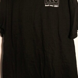 May include: Black t-shirt with a white graphic of the band Tool's logo and the text "local crew 2001".