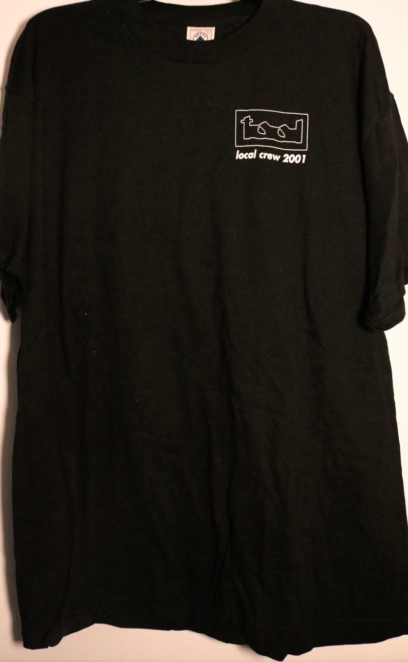 May include: Black t-shirt with a white graphic of the band Tool's logo and the text "local crew 2001".