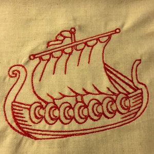 Puede incluir: Diseño de barco vikingo bordado en rojo sobre un fondo de tela beige.