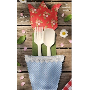 Könnte beinhalten: Ein handgefertigter Besteckhalter in Blumenform mit rotem Blumendesign, der eine weiße Gabel und einen Löffel hält. Der Halter befindet sich auf einer Holzoberfläche mit dem Text "Flower Silverware Sewing Pattern" und "Fast & easy to make".