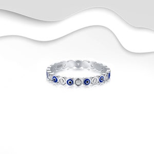 May include: A silver ring featuring a circle of blue evil eyes and clear stones. The ring is marked with the number "S925".
