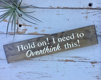May include: A rustic wooden sign with the text "Hold on! I need to Overthink this!" in white lettering.