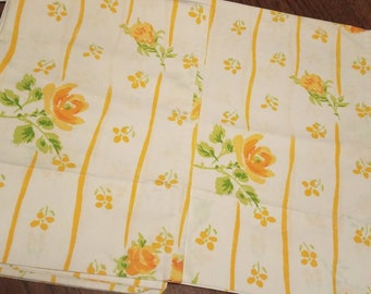 Puede incluir: Dos fundas de almohada de tela blanca con rayas amarillas y un patrón floral amarillo. Las flores son rosas amarillas con hojas verdes.