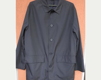 May include: A dark blue long-sleeved jacket with a button-up front and two pockets. The jacket has a collar and is hanging on a hanger.