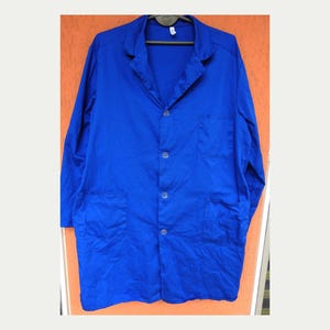 Könnte beinhalten: Ein langärmliger, blauer Arbeitsmantel mit Knopfleiste und mehreren Taschen.