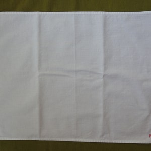 Può includere: Asciugamano da bagno in cotone bianco con logo TWA ricamato in rosso.