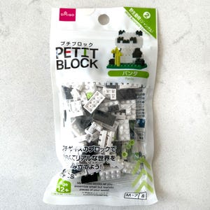 May include: A clear plastic bag of Petit Block building blocks. The bag features the text "DAISO", "PETIT BLOCK", and "Panda". The bag also shows a completed panda figure made of white, black, and green blocks. The age range is 12+.