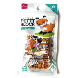 May include: A Daiso Petit Block construction set in a plastic bag featuring a fox model. The packaging displays the text Petit Block, Fox, and Japanese characters. Inside are small orange, white, and black building bricks for assembly.