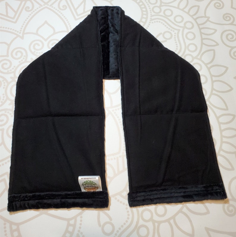 May include: Black velvet neck wrap with a quilted interior. The wrap has a small green label with the text "Dreamweaver" on it.