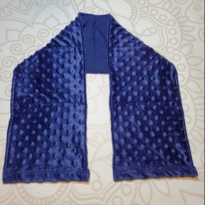 May include: A navy blue weighted sensory scarf with a soft, textured fabric. The scarf is designed with multiple sewn-in pockets filled with small, raised dots.