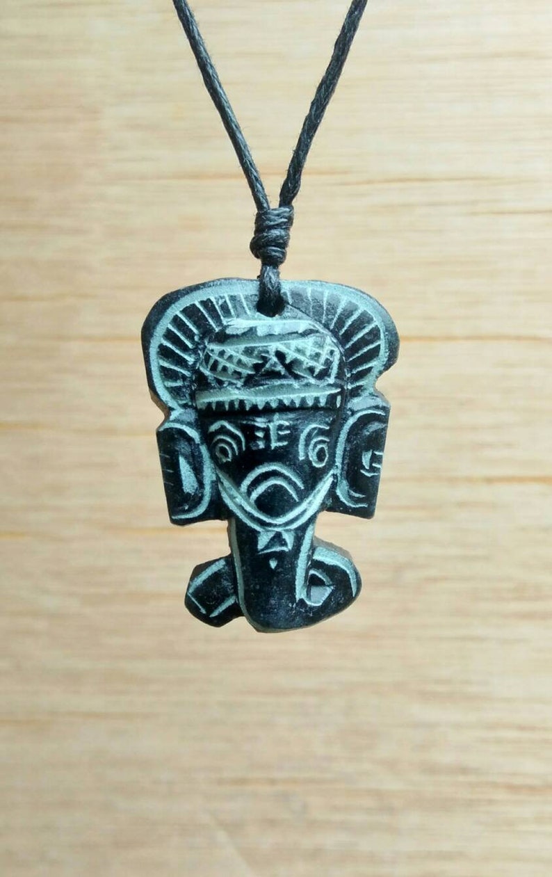 May include: Black and white carved pendant of the Hindu deity Ganesha, on a black cord necklace.