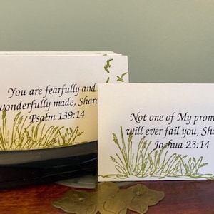 May include: Two white cards with green grass and bird illustrations. The top card reads "You are fearfully and wonderfully made, Sharon. Psalm 139:14". The bottom card reads "Not one of My promises will ever fail you, Sharon. Joshua 23:14".