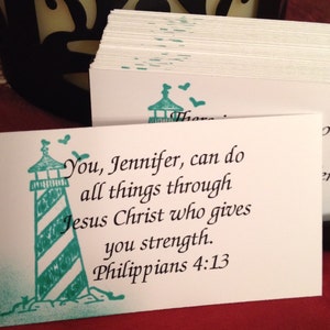 May include: A white card with a teal lighthouse graphic and the text "You, Jennifer, can do all things through Jesus Christ who gives you strength. Philippians 4:13"